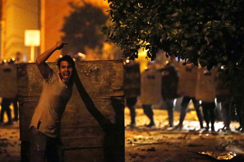 Um manifestante grita por trás de um escudo enquanto a tropa de choque avança durante um protesto contra o governo do presidente Mario Abdo Benitez, em Assunção, no Paraguai — Foto: Jorge Saenz/AP Photo
