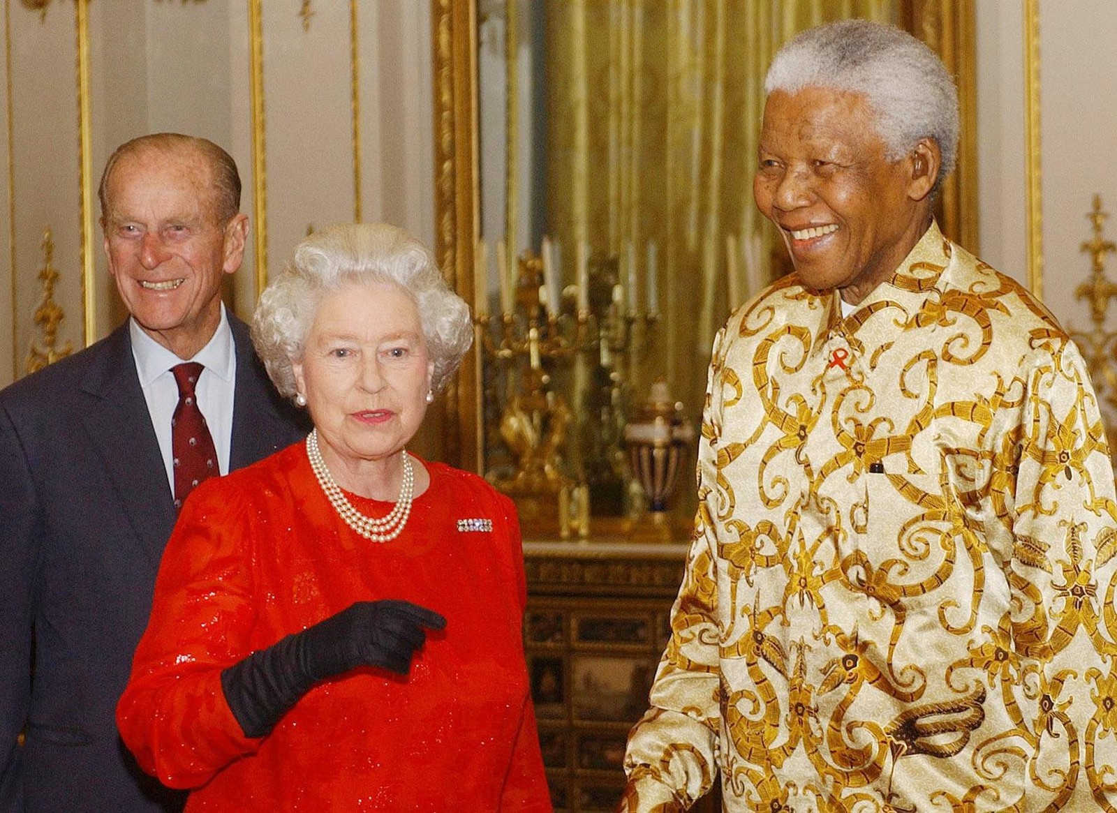 O casal real encontra Nelson Mandela durante uma recepção no Palácio de Buckingham, em outubro de 2003 — Foto: KIRSTY WIGGLESWORTH/AP