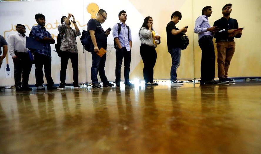 In this Sept. 17, 2019, photo job seekers line up to speak to recruiters during an Amazon job fair in Dallas. On Friday, Oct. 4, the U.S. government issues the September jobs report. (AP Photo/LM Oter