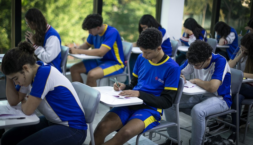 Estudantes recebendo materiais do programa Pé-de-Meia.