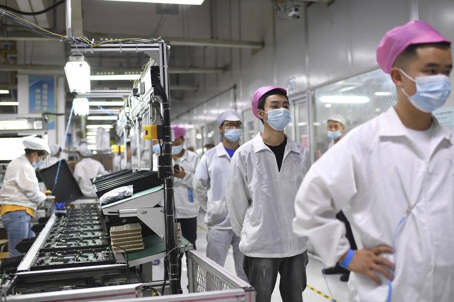 Trabalhadores chineses em fila para teste em fábrica de iPhones