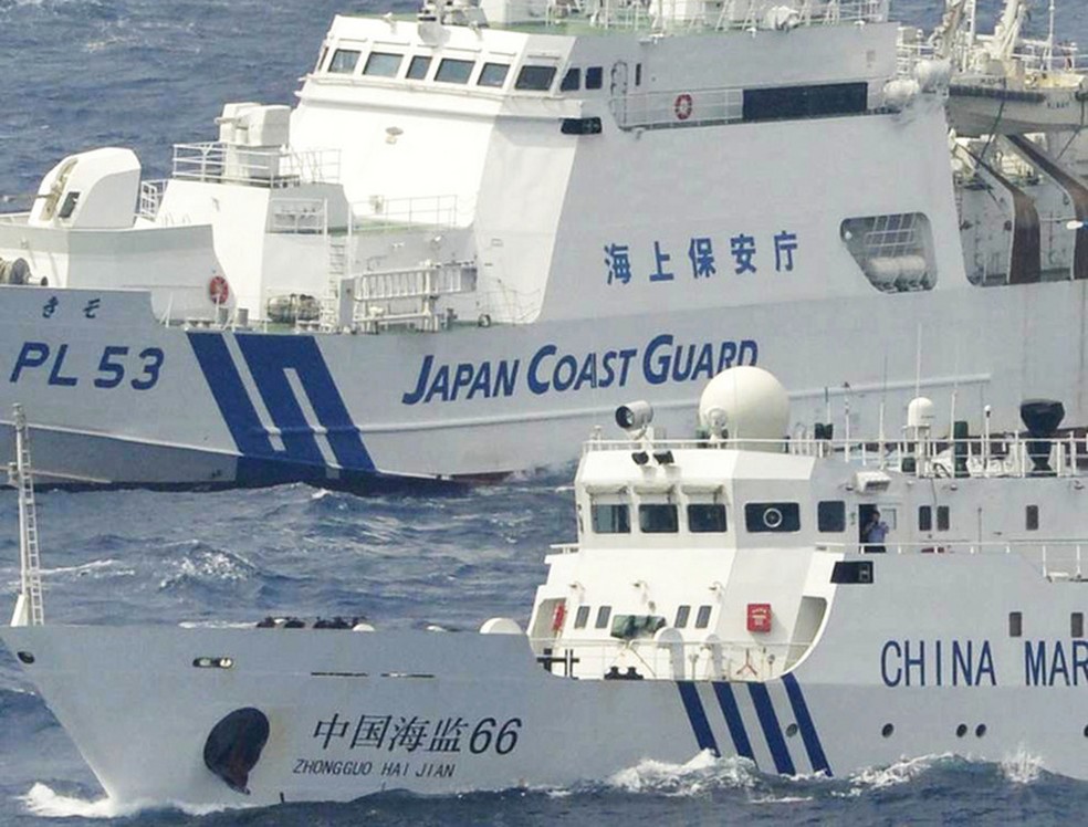 Proximidade perigosa: navio da Guarda Costeira do Japão ao lado de barco chinês de patrulha perto das ilhas em disputa — Foto: Kyodo News/AP