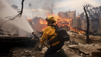 Bombeiro combate incêndio no bairro de Pacific Palisades, um dos mais atingidos pelo fogo em Los Angeles — Foto: Etienne Laurent/AP