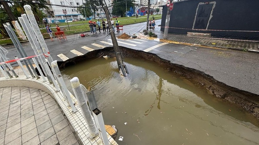 Em São Vicente (SP), uma cratera se abriu no cruzamento da avenida Marechal Deodoro com a Rua Pero Lopes de Souza, ao lado do Edifício Solaris — Foto: Reprodução/Defesa Civil
