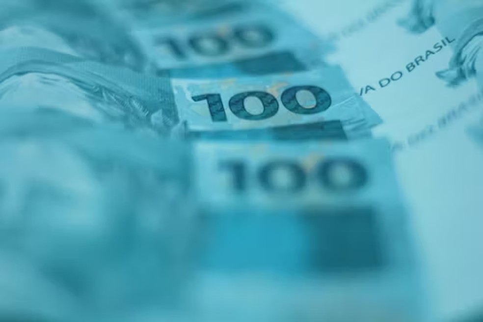 Representação gráfica de uma moeda de dólar e real em balança.