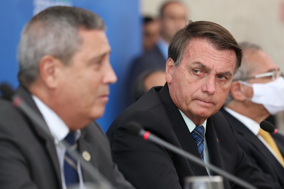 Então presidente Jair Bolsonaro observa Braga Netto, então ministro da Casa Civil — Foto: Marcos Corrêa/PR