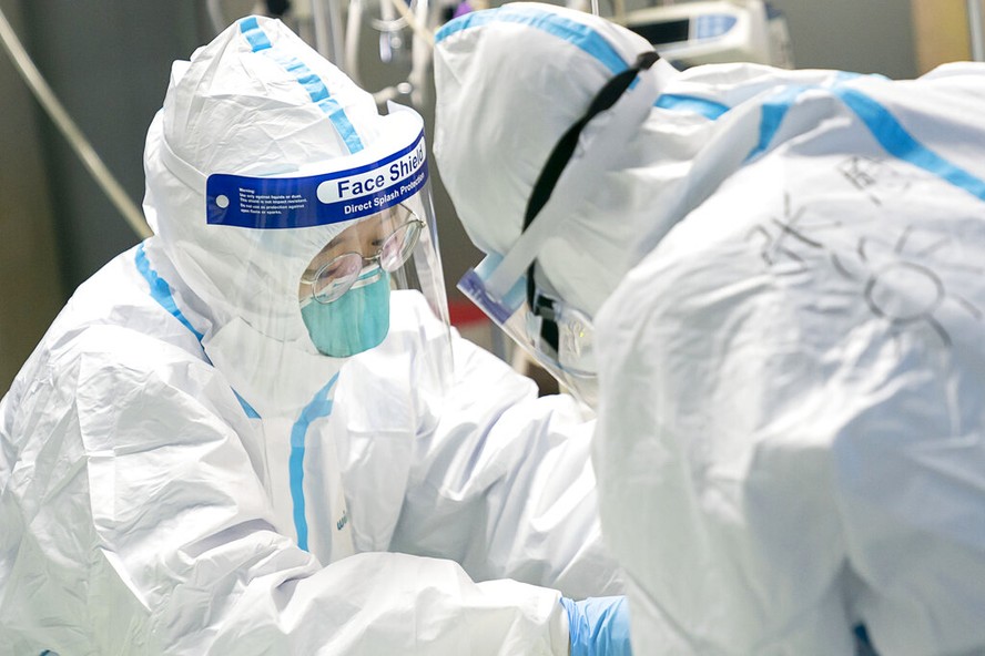 Médicos atendem paciente com coronavírus no Hospital Zhongnan, em Wuhan, na China