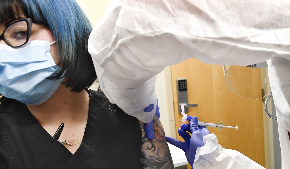 Mulher recebe injeção com vacina desenvolvida pela Moderna contra o novo coronavírus — Foto: Hans Pennink/AP Photo