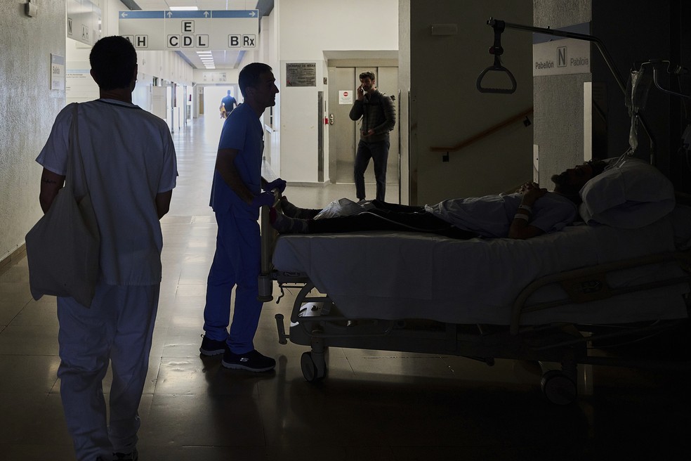 Funcionário de hospital de Pamplona realoca um paciente, durante queda de energia na Espanha em abril de 2025 — Foto: Miguel Oses/AP Photo