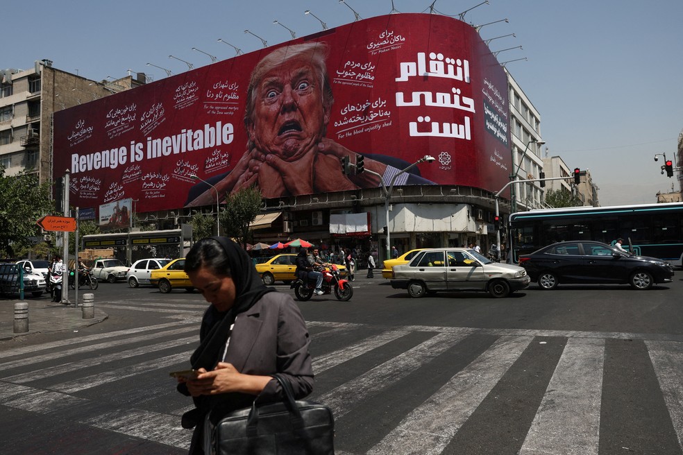 Uma mulher caminha perto de um outdoor com a imagem do presidente dos EUA, Donald Trump, em um prédio em Teerã, Irã , em 27 de julho de 2026 — Foto: Majid Asgaripour/WANA (West Asia News Agency) via REUTERS