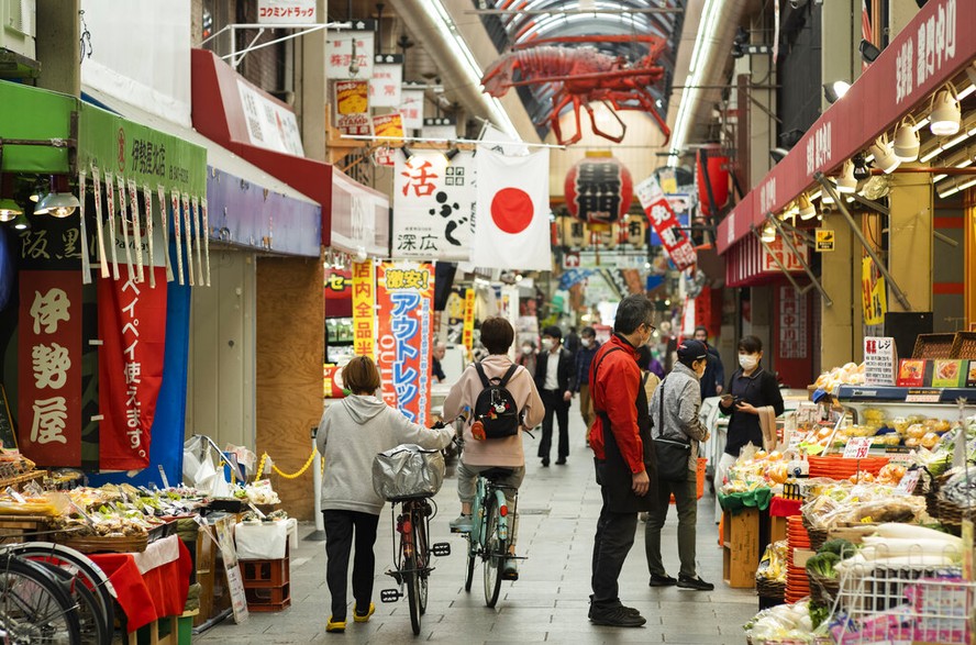Pessoas com máscaras fazem compras no mercado Kuromon Ichiba, em Osaka, Japão