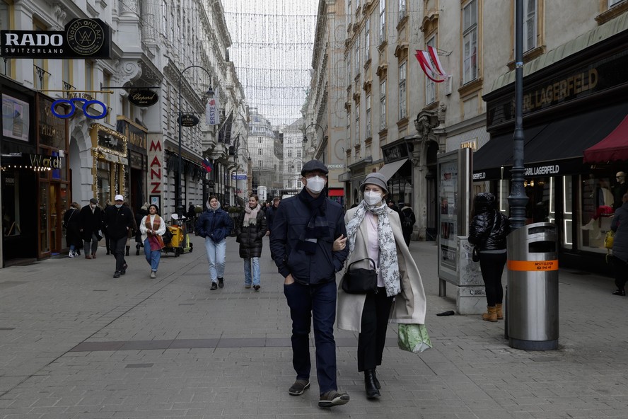 People walk over through a shopping street in Vienna, Austria, Friday, Nov. 19, 2021. Austrian Chancellor Alexander Schallenberg says the country will go into a national lockdown to contain a fourth w