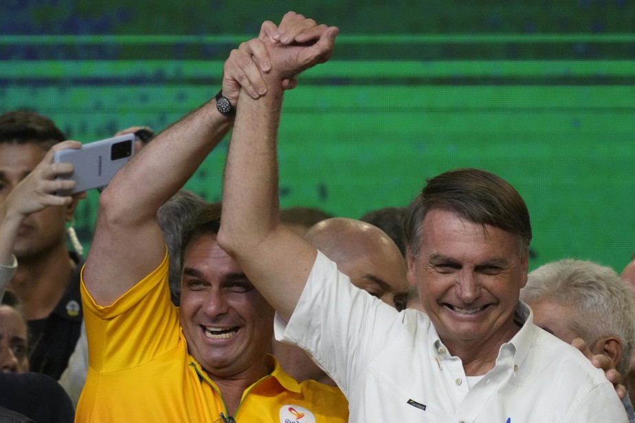 Brazil's President Jair Bolsonaro celebrates with his, son Senator Flavio Bolsonaro,  during an event with members of his Liberal Party and with supporters as he presents his candidacy for the next pr