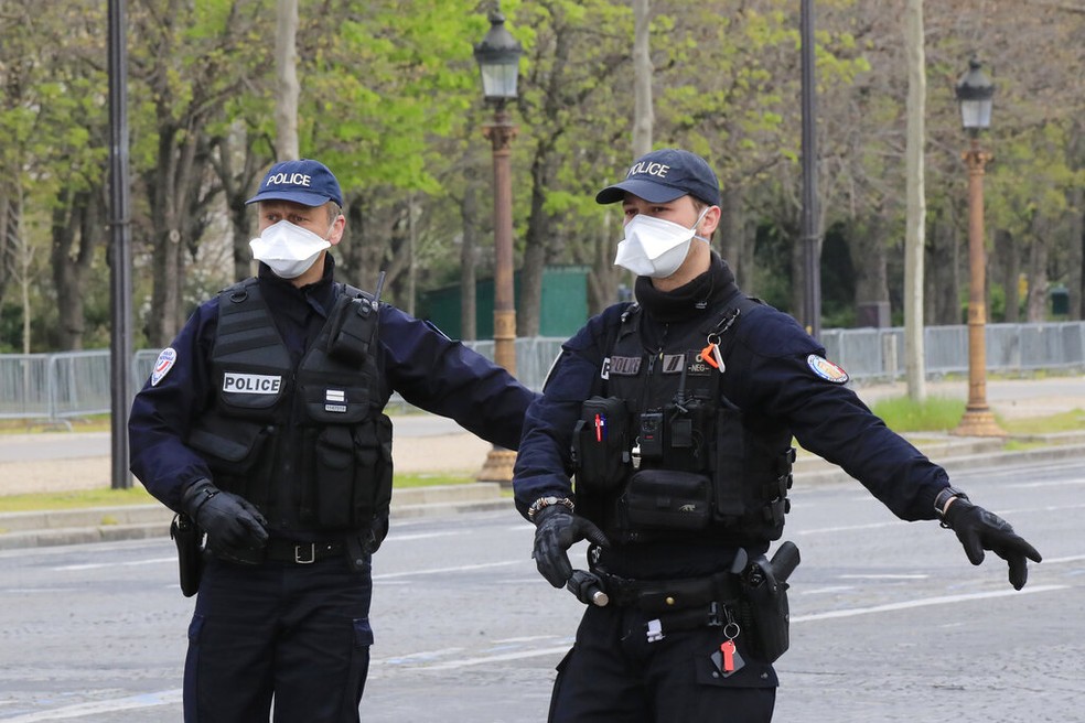 Policiais se protegem do coronavírus na Champs Elysees, em Paris — Foto: AP Photo/Michel Euler