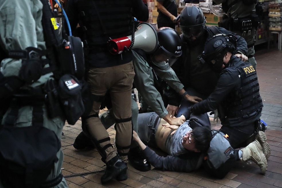 Imagem de arquivo mostra policiais prendendo ativista durante protesto em Hong Kong — Foto: Lee Jin-man/AP Photo