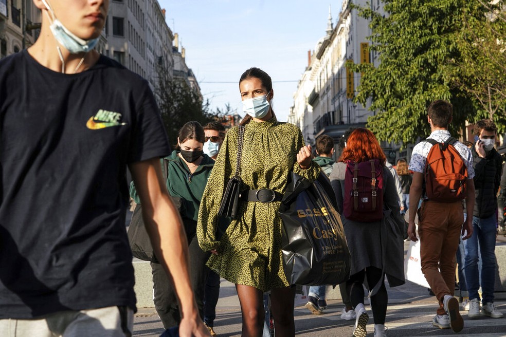 Pessoas usando máscaras caminham pelo centro de Lyon, na França — Foto: Laurent Cipriani/AP Photo