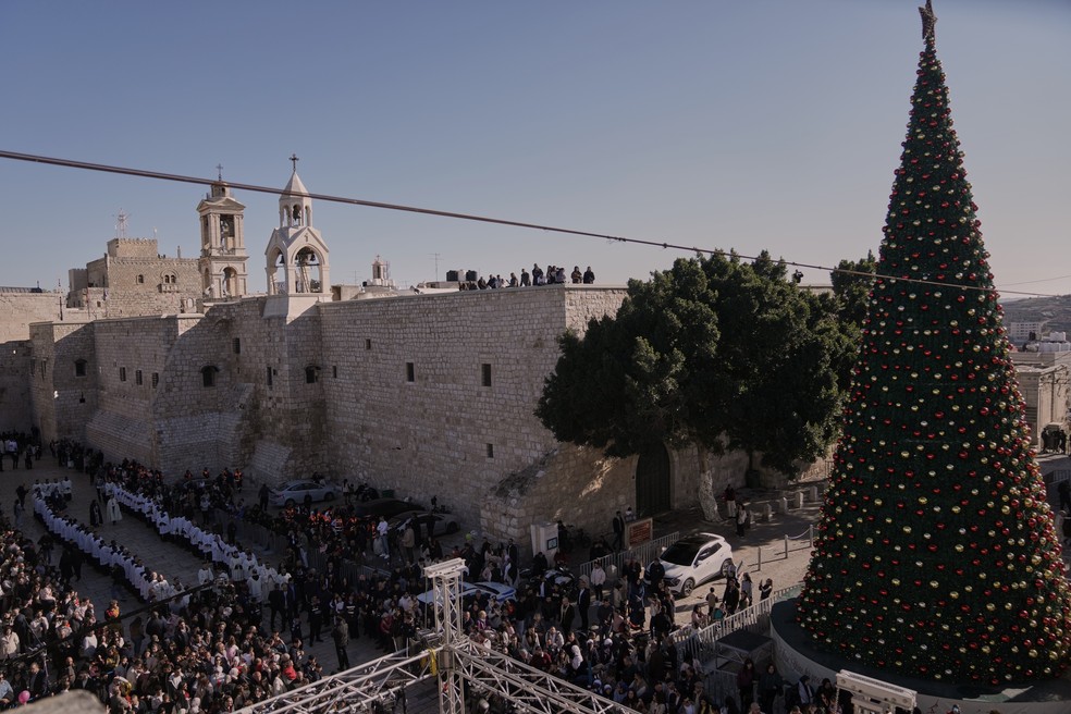 Clérigos católicos caminham em procissão ao lado da Igreja da Natividade — Foto: Mahmoud Illean/AP