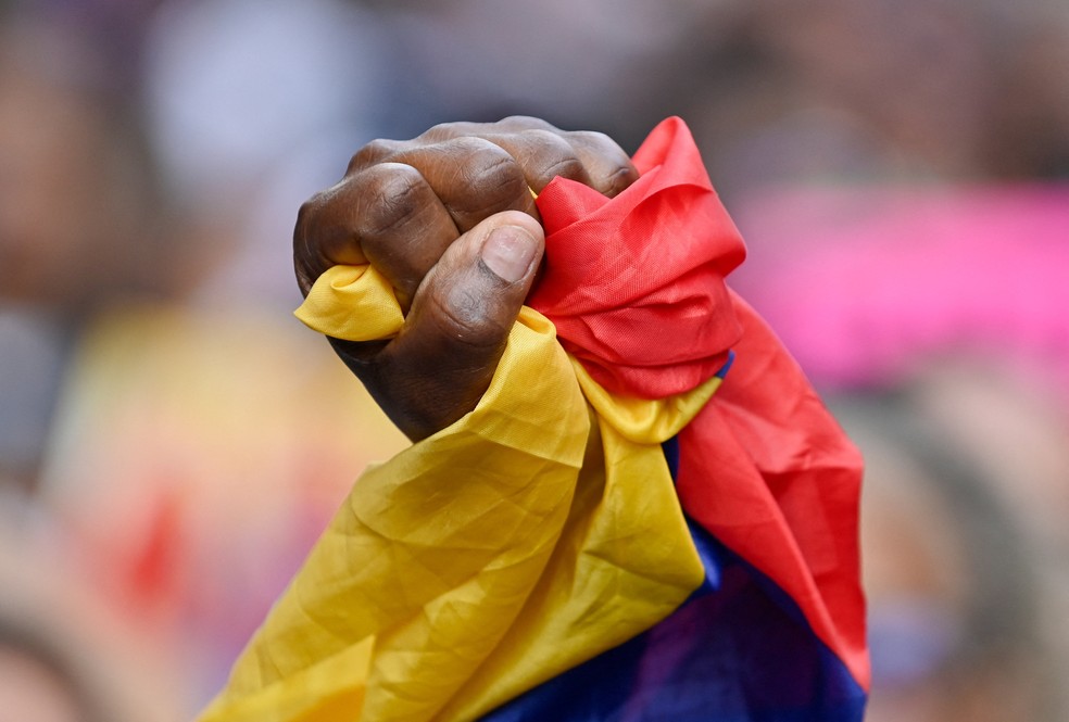 Homem segura a bandeira da Venezuela em manifestação perto da Assembleia após invasão do país pelos Estados Unidos — Foto: Maxwell Briceno/Reuters