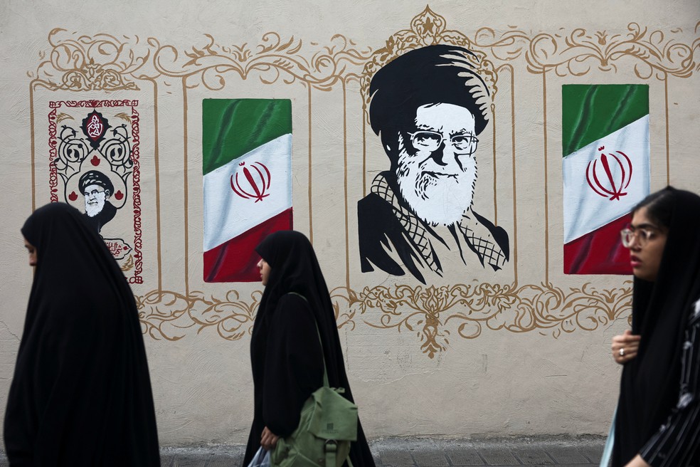 Pessoas passam por um mural que retrata o falecido líder supremo do Irã, aiatolá Ali Khamenei, em uma rua de Teerã, Irã, em 13 de agosto de 2026 — Foto: Majid Asgaripour/WANA (West Asia News Agency) via REUTERS