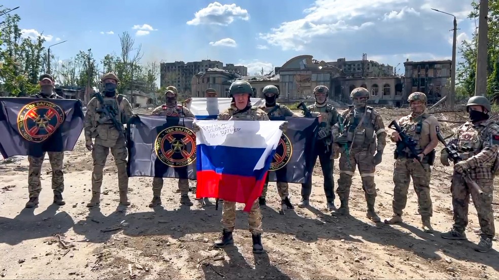 Yevgeny Prigozhin segura bandeira da Rússia ao lado de mercenários do Grupo Wagner — Foto: Prigozhin Press Service via AP (Arquivo)