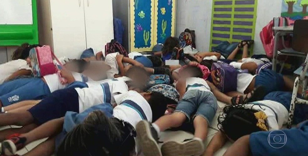 Reprodução de imagem compartilhada por moradores em redes sociais: alunos de uma escola da Vila do Pinheiro deitados no chão durante um tiroteio — Foto: Reprodução de TV