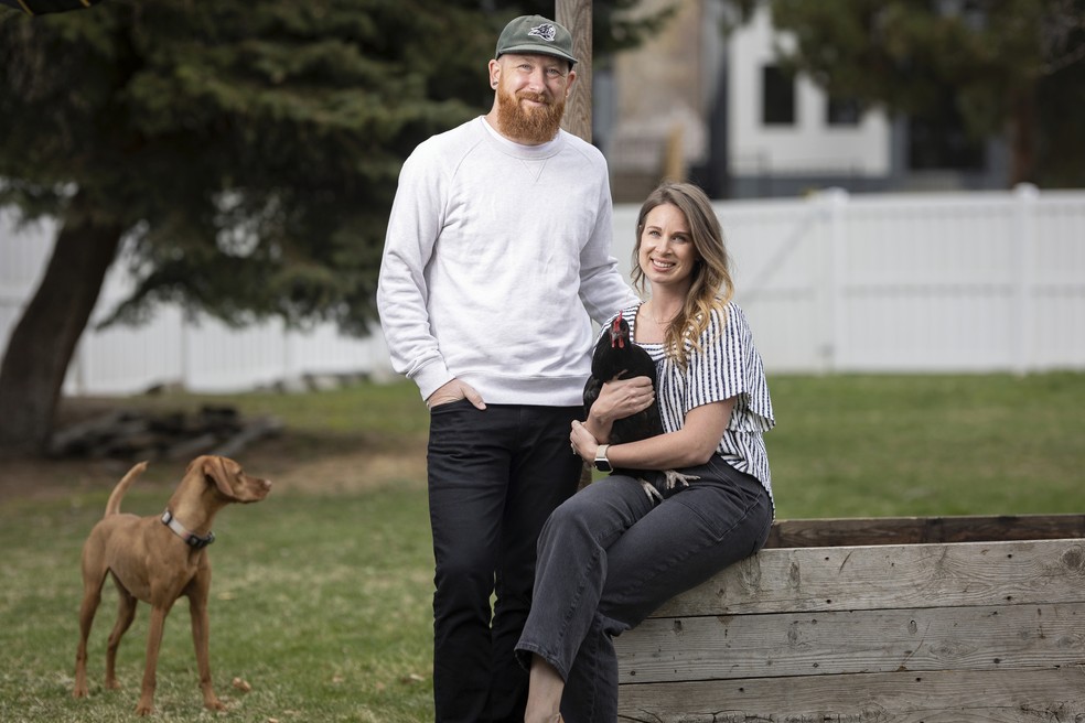 Aaron e Carrie Friesen posam para uma foto com galinhas e a cadela Geórgia no quintal de sua casa em Boise, Idaho, EUA, 12 de abril de 2023 — Foto: AP/Kyle Green