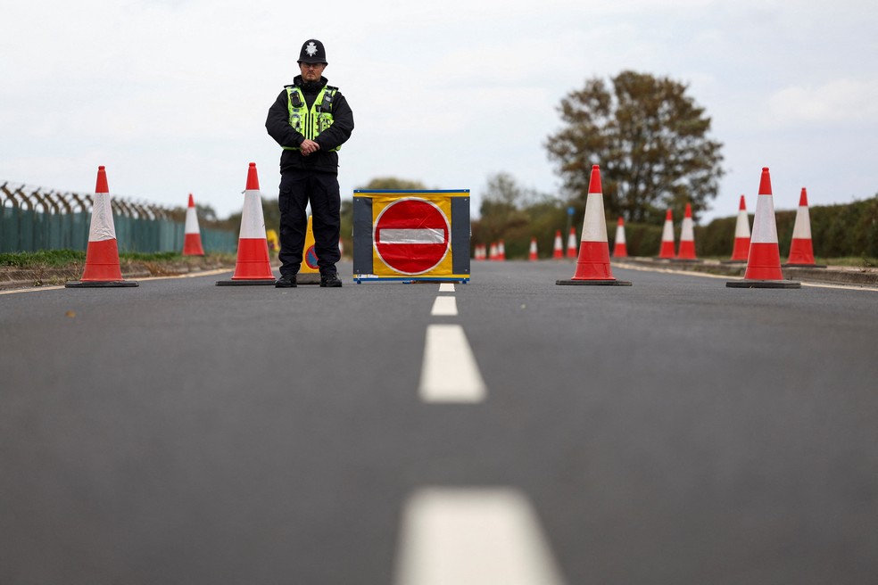 Um policial faz a segurança em um bloqueio de estrada nos arredores da base aérea RAF Fairford, depois que a polícia declarou uma ocorrência de grande escala no local — Foto: REUTERS/Toby Shepheard