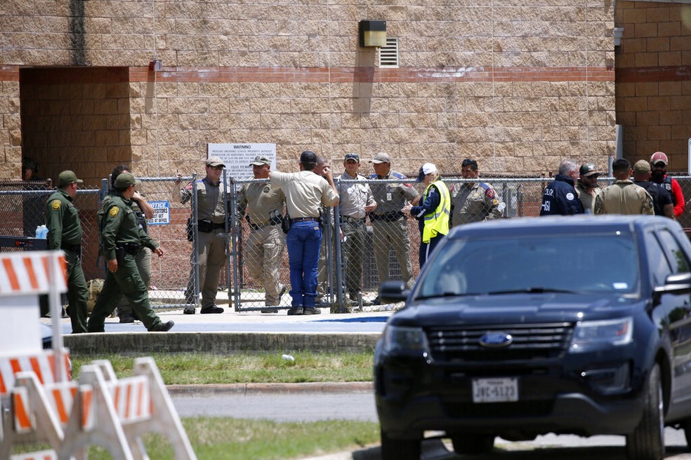 Policiais e socorristas se reúnem do lado de fora da Robb Elementary School, em Uvalde, Texas, onde ocorreu um tiroteio nesta terça-feira (24 de maio de 2022), e deixou ao menos duas crianças mortas — Foto: Dario Lopez-Mills/AP