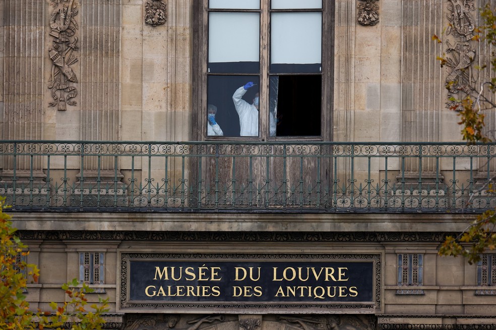 Membros de uma equipe forense inspecionam uma janela que se acredita ter sido usada no assalto ao Museu do Louvre, em Paris, na França — Foto: Gonzalo Fuentes/Reuters