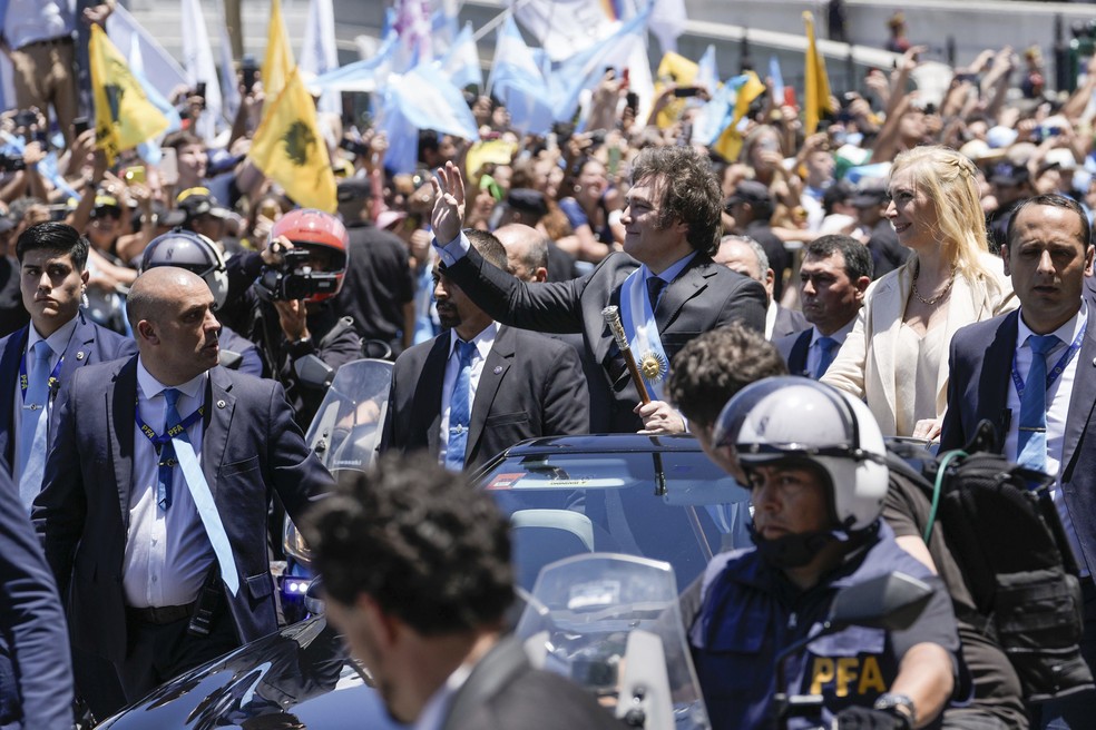 O recém-empossado presidente da Argentina, Javier Milei, acena para os apoiadores de um carro em direção à casa do governo Casa Rosada em Buenos Aires, na Argentina, no domingo, 10 de dezembro de 2023 — Foto: AP Photo/Rodrigo Abd