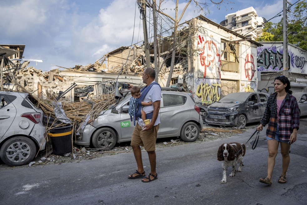 Moradores de Tel Aviv observam estragos causados por mísseis disparados pelo Hamas — Foto: Oded Balilty/AP