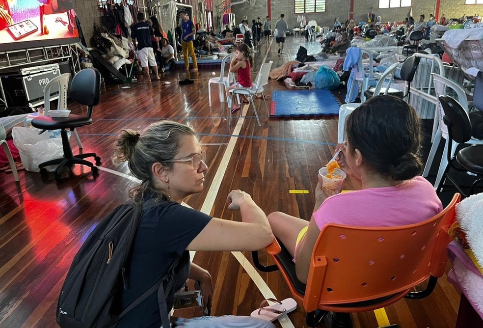 Camila Bolzan de Campos (esq.) presta atendimento em Canoas (RS) durante a tragédia das enchentes de 2024 — Foto: Gabriel Teixeira/Divulgação