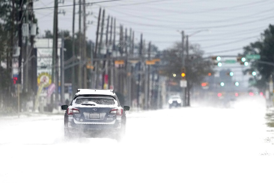 Carro trafega por via coberta de neve em Spring, no Texas, após tempestade