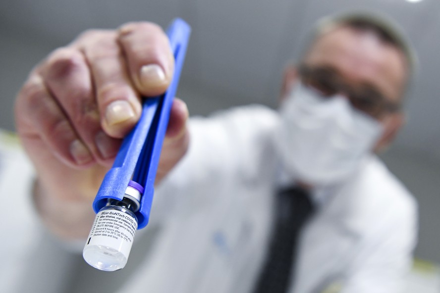 Um profissional de saúde segura um frasco da vacina Pfizer-BioNTech em Leuven, na Bélgica