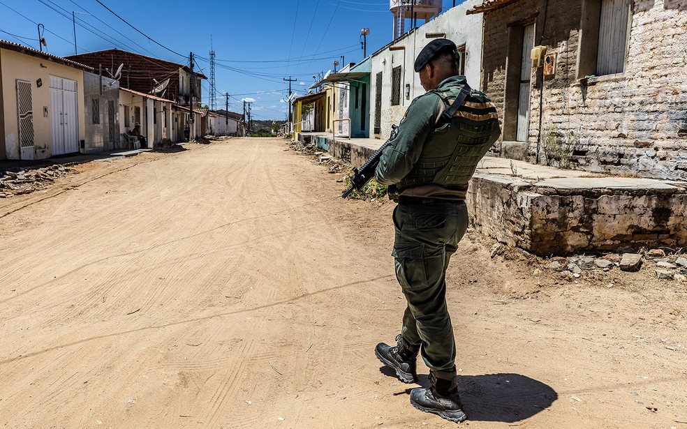 Policial com fuzil em Uiraponga: briga entre lideranças de facção esvazia distrito e moradores temem voltar para casa, um ano depois de migração em massa — Foto: Jarbas Oliveira/Valor