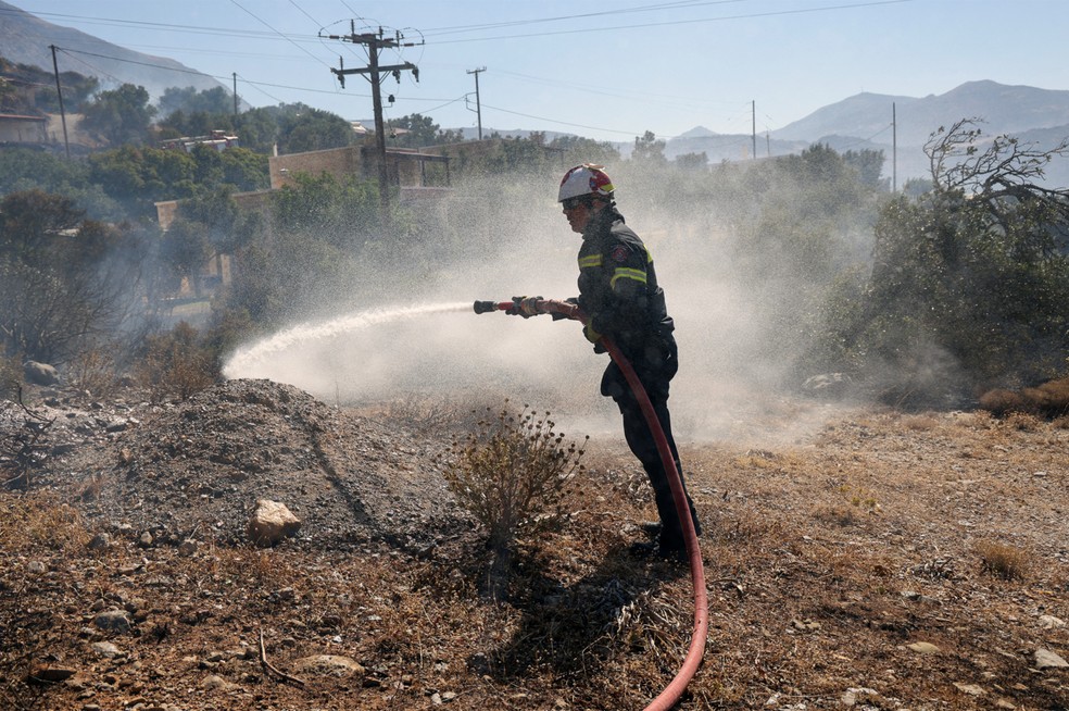 Um bombeiro combate um incêndio florestal perto da praia de Triopetra, na ilha de Creta, Grécia , em 30 de julho de 2026 — Foto: REUTERS/Stefanos Rapanis