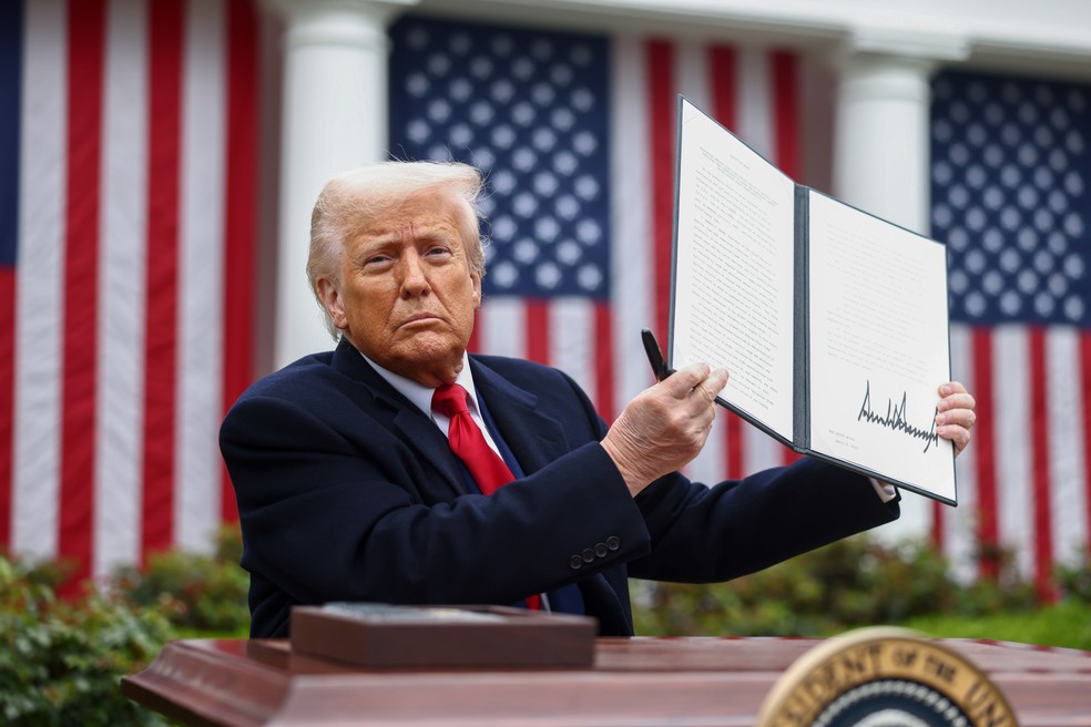 Presidente dos EUA, Donald Trump, com um de seus decretos — Foto: Jim Lo Scalzo/EPA/Bloomberg