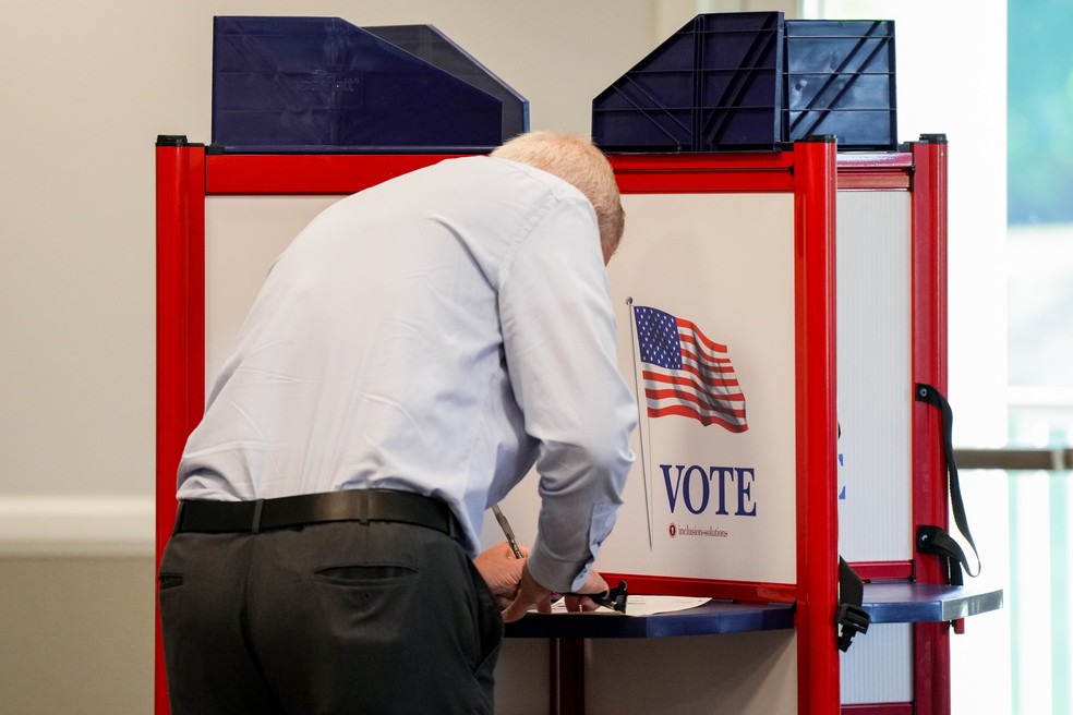 Um eleitor deposita seu voto em uma seção eleitoral dentro do Boone Links Golf Course Clubhouse durante as eleições primárias em Florence, Kentucky, EUA, na terça-feira, 19 de maio de 2026. — Foto: Jeffrey Dean/Bloomberg