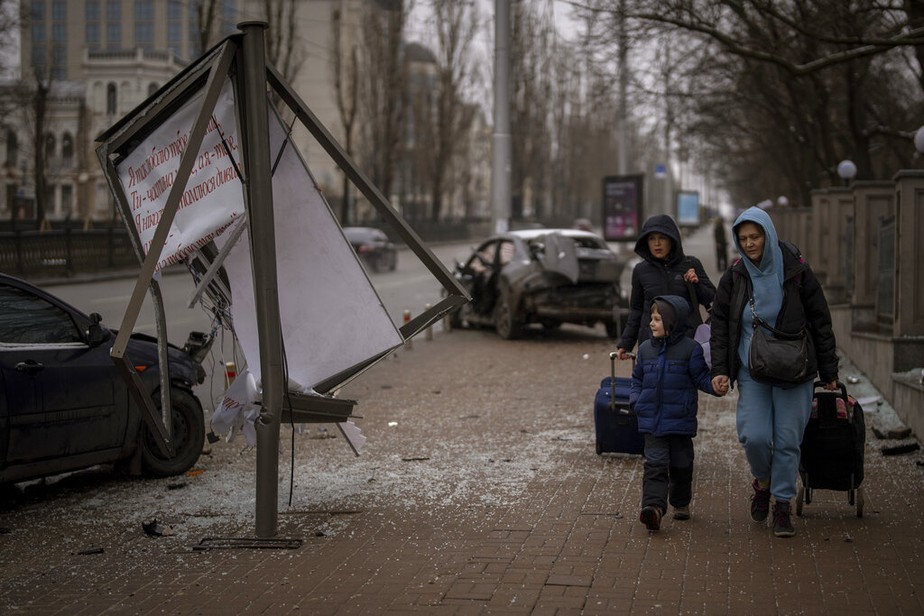 Um grupo de mulheres e um menino caminham até a estação de trem enquanto tentam deixar Kiev, Ucrânia