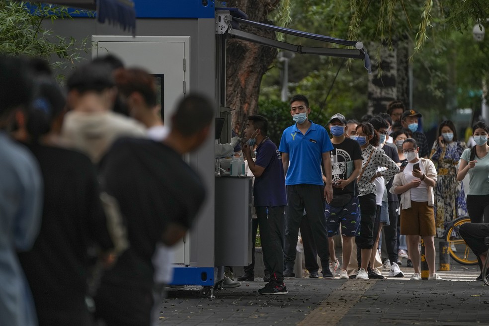 Chineses fazem fila para serem testados para a covid-19 em Pequim — Foto: Andy Wong/AP