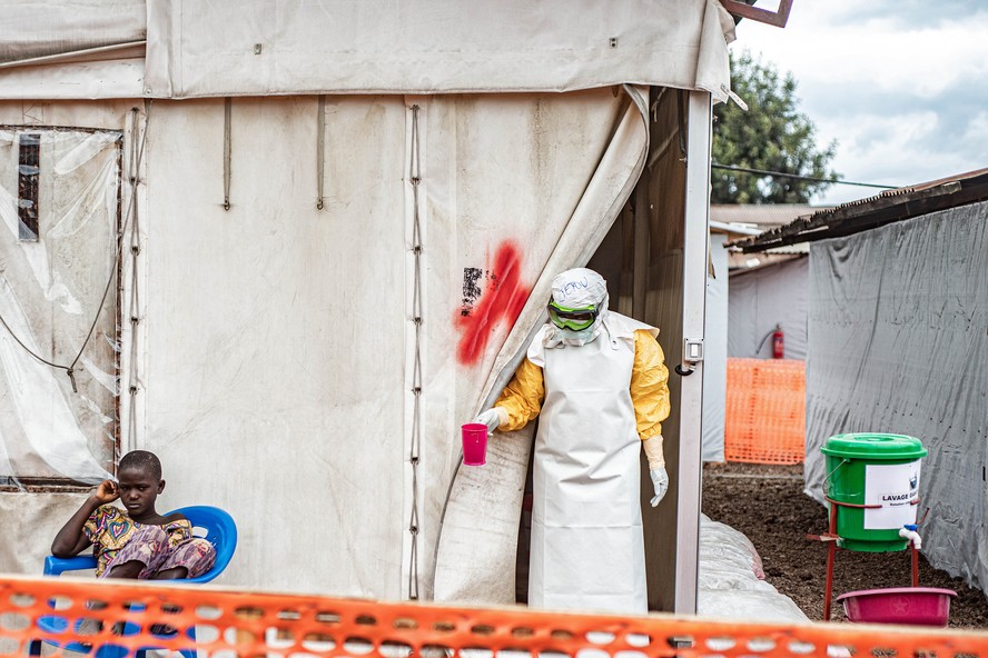 Uma profissional de saúde visita um paciente em uma unidade de isolamento em um centro de tratamento de Ebola em Monigi, República Democrática do Congo, em junho