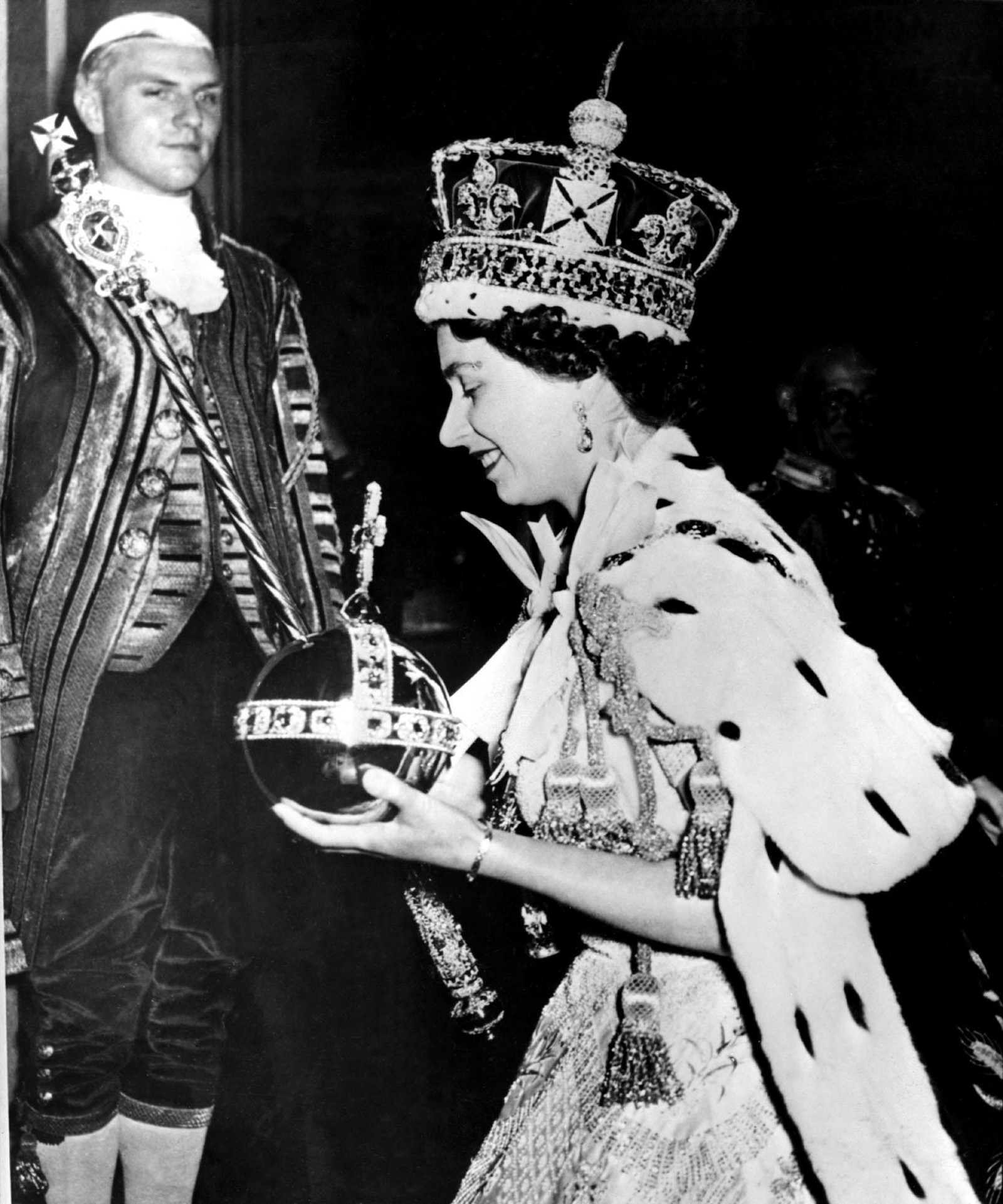Em 2 de junho de 1953, foi coroada a primeira mulher na Grã-Bretanha desde a rainha Vitória. Elizabeth II usava a coroa imperial adornada com joias e carregava o Orbe, na mão esquerda, e o Cetro com a Cruz — Foto: AP Photo/Fls