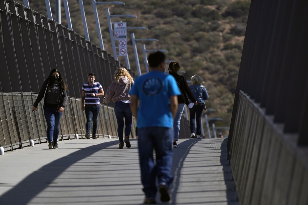 Pessoas caminham por ponte que conecta Tijuana, no México, a São Diego, nos Estados Unidos (13/10/2021) — Foto: Gregory Bull/AP