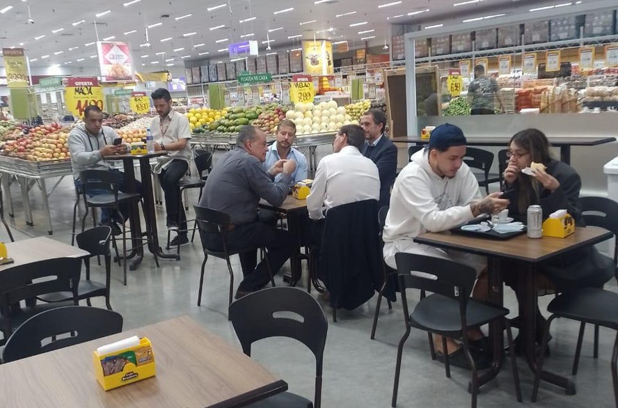 Café na mesa dividida entre Alexandre Bompard (terno azul escuro), presidente global do Carrefour, Marco Oliveira (camisa azul clara), CEO do Atacadão, Pablo Lorenzo (camisa branca), CEO do Carrefour