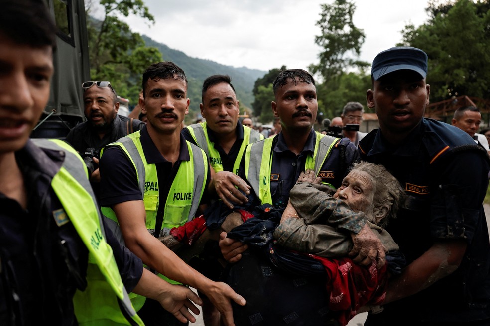 Policiais carregam um sobrevivente para um local seguro após uma enxurrada em Trishuli, no distrito de Nuwakot, Nepal, em 26 de agosto de 2026 — Foto: REUTERS/Navesh Chitrakar