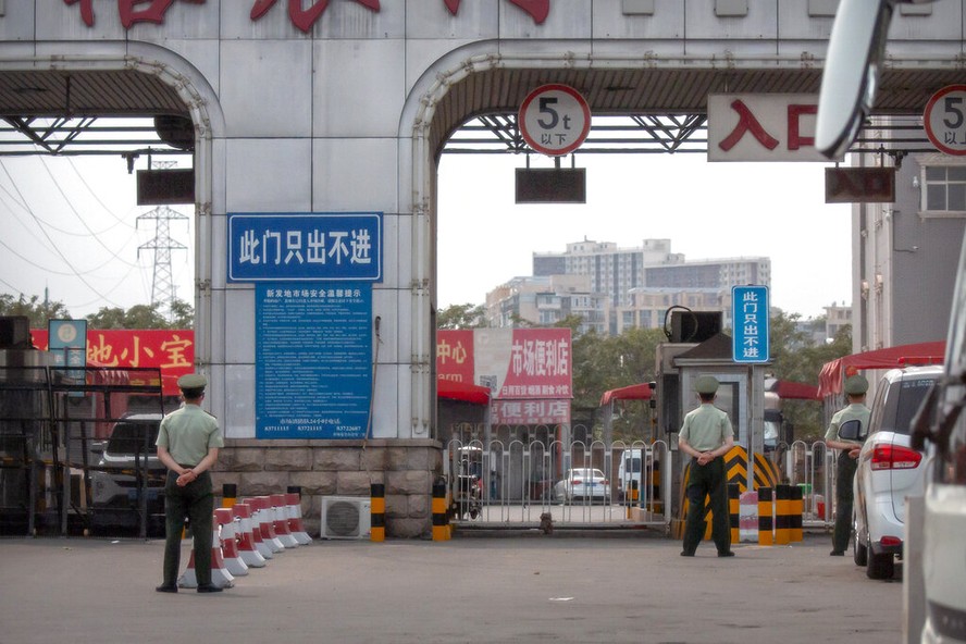 Policiais fazem barricada com cercas no mercado de Xinfadi, em Pequim, após novos casos de covid-19