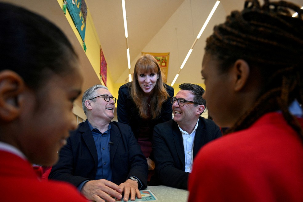 O primeiro-ministro britânico Keir Starmer, a ex-vice-primeira-ministra Angela Rayner e o prefeito da Grande Manchester, Andy Burnham, encontram-se com alunos durante uma visita a uma escola primária em Ashton-under-Lyne, Grande Manchester — Foto: PAUL ELLIS/Pool via REUTERS