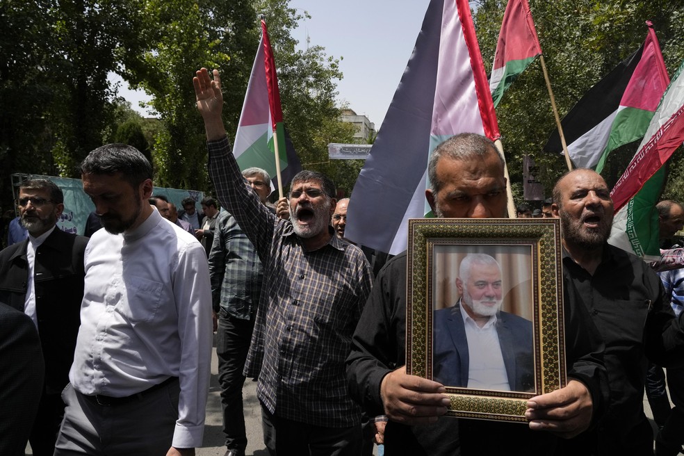  Membros do Conselho da Universidade de Teerã entoam slogans em uma manifestação para condenar o assassinato do líder do Hamas, Ismail Haniyeh, mostrado na foto, na universidade, em Teerã, Irã — Foto: Vahid Salemi/AP