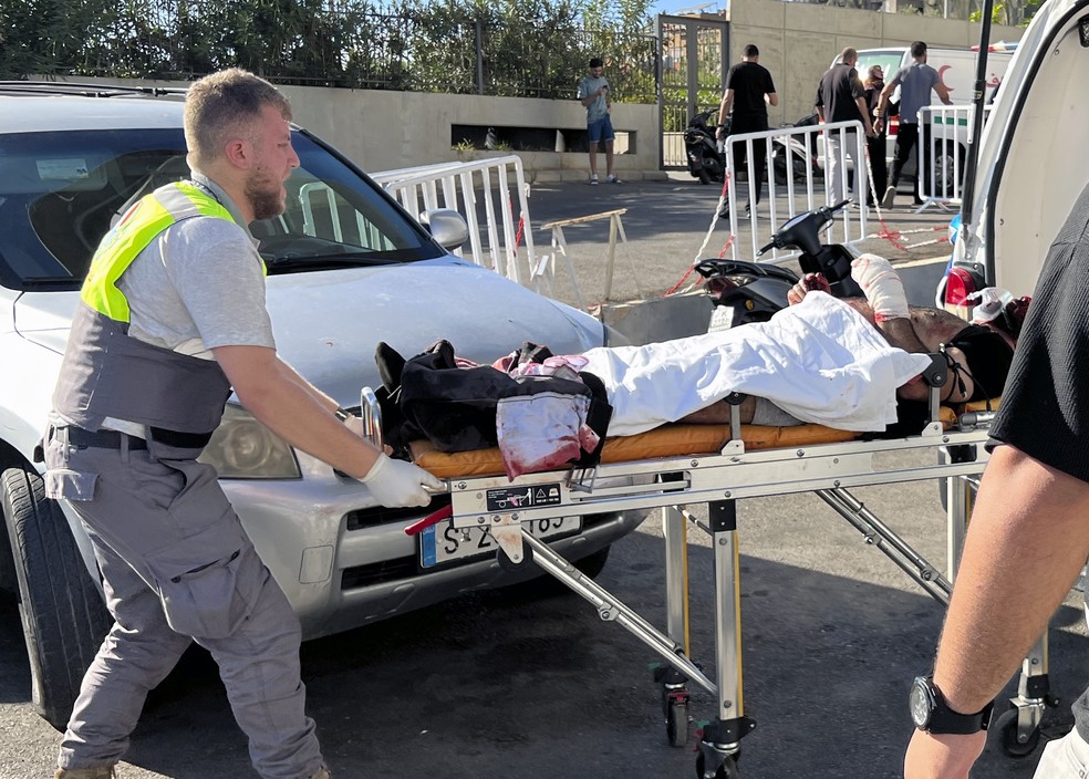 Um socorrista da Defesa Civil carrega um homem ferido cujo pager explodiu no hospital al-Zahraa, em Beirute, Líbano — Foto: Hussein Malla/ AP Photos